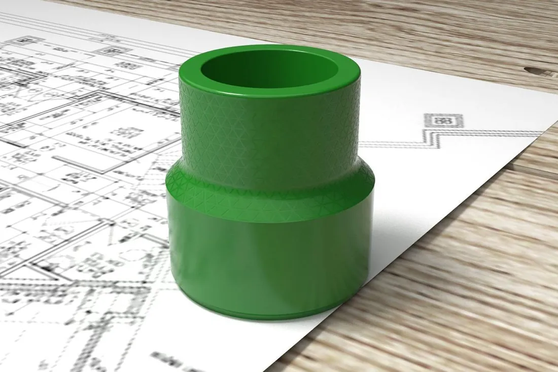 Finished green pipe fitting on technical drawings